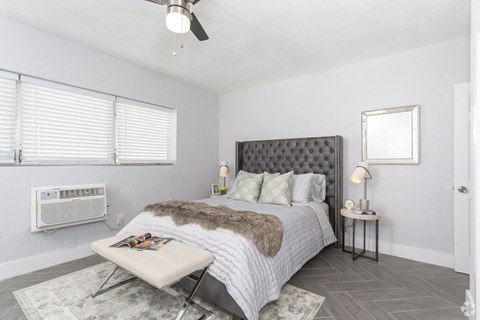 a bedroom with a bed and two windows