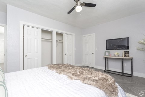 a bedroom with a large bed and a ceiling fan