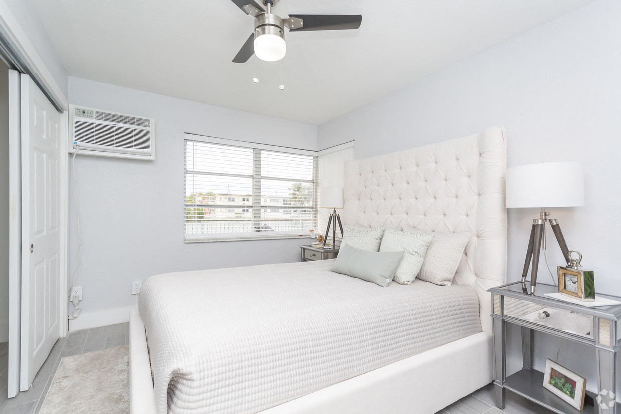a bedroom with a large bed and a ceiling fan
