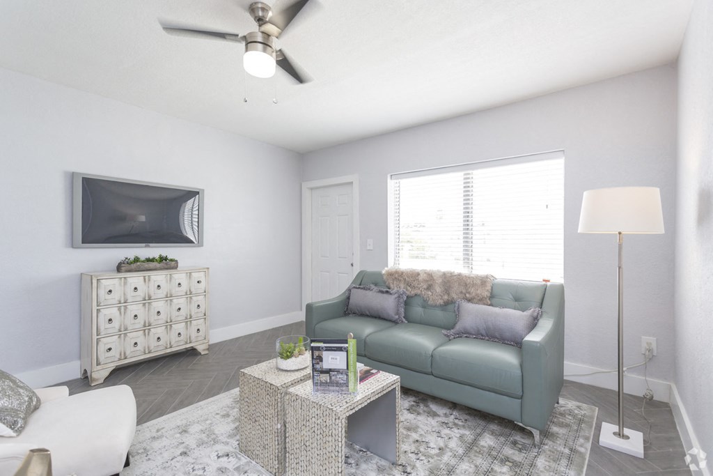 a living room with a green couch and a tv