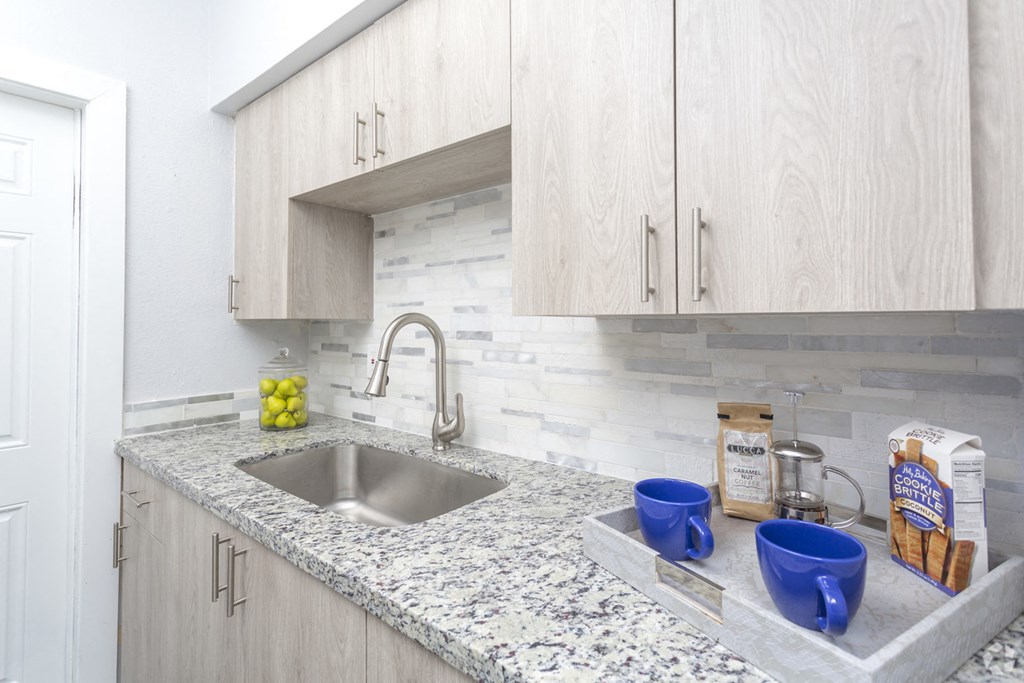 a kitchen with marble counter tops and a sink