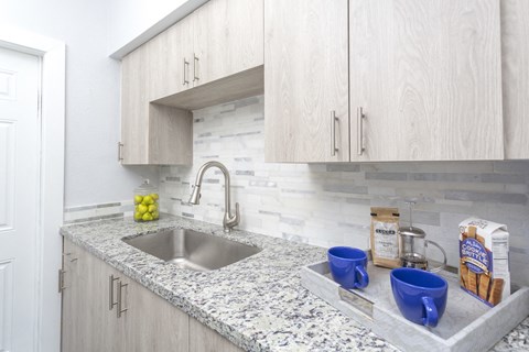a kitchen with marble counter tops and a sink