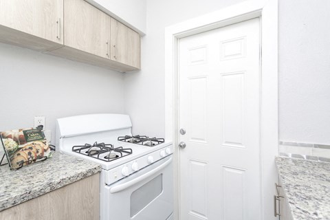a kitchen with a white stove and a white door
