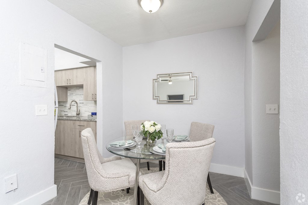 a dining room with a glass table and chairs