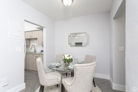 a dining room with a glass table and chairs