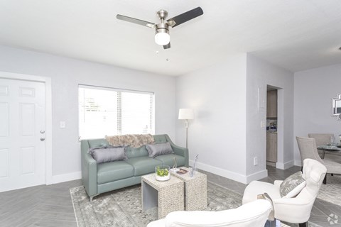 a living room with a couch and a ceiling fan