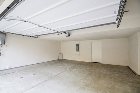 an empty garage with white walls and a concrete floor