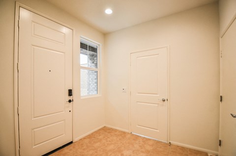 a bedroom with two white doors and a window