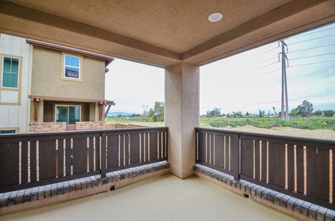 a balcony with a view of a field and a house