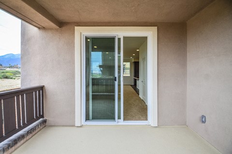 a balcony with a sliding glass door and a view of a hallway