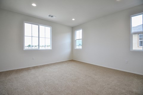 a room with carpet and two windows