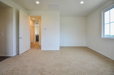 an empty living room with white walls and carpet