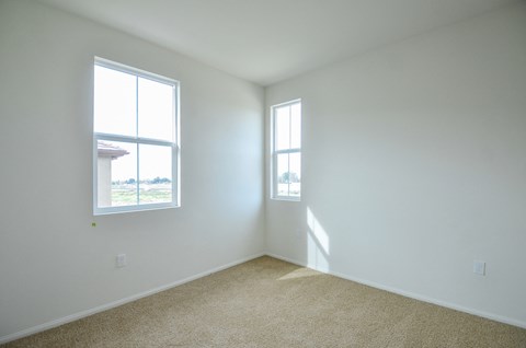 an empty room with two windows in it