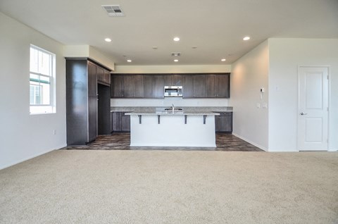 an empty kitchen with a white counter top