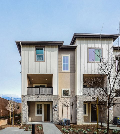 a two story house with a sidewalk in front of it