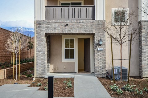 the entrance to an apartment building with a concrete sidewalk