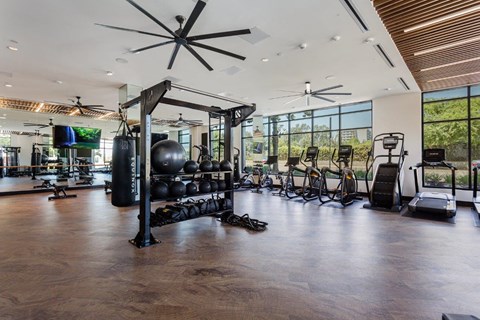 A gym with a variety of equipment including treadmills, weights, and exercise bikes.