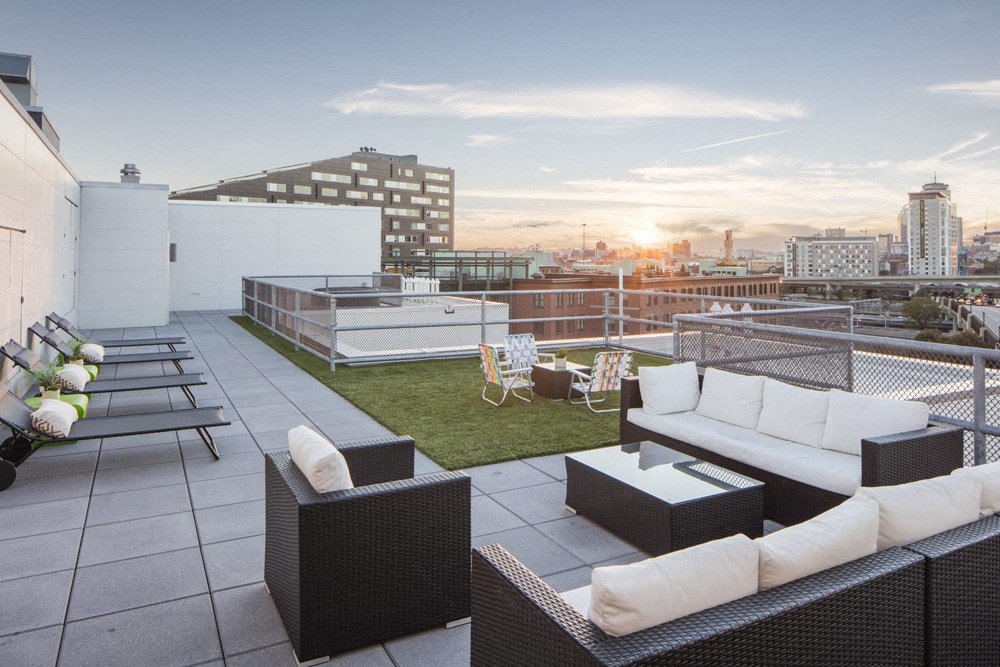 a roof terrace with furniture and a view of the city