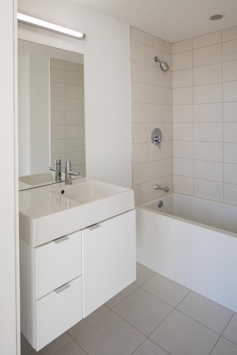 a white bathroom with a sink and a tub
