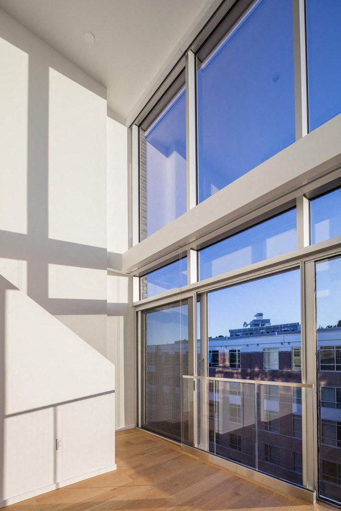 a living room with large windows and a staircase