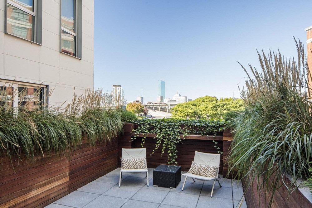 a patio with two chairs and a city skyline in the background