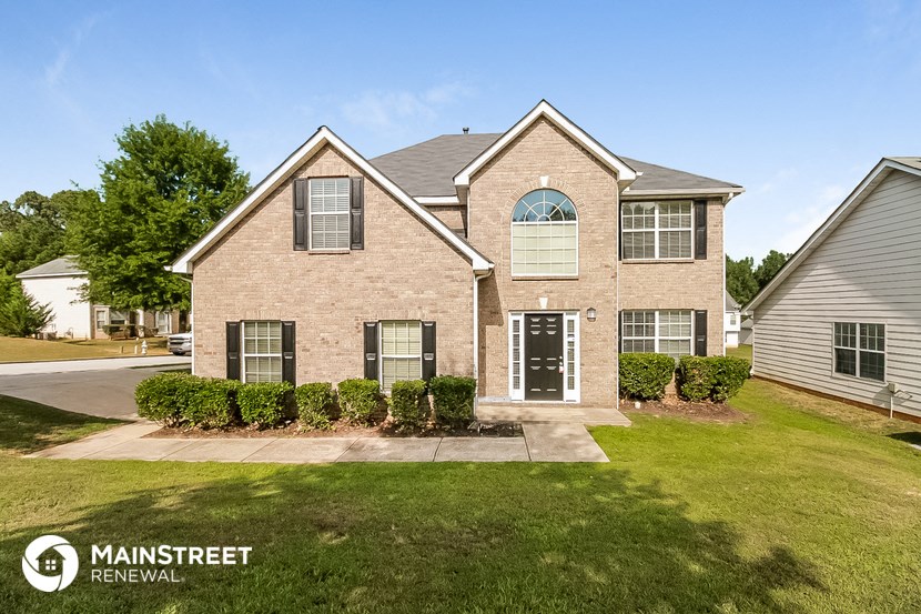 a large brick house with a lawn in front of it