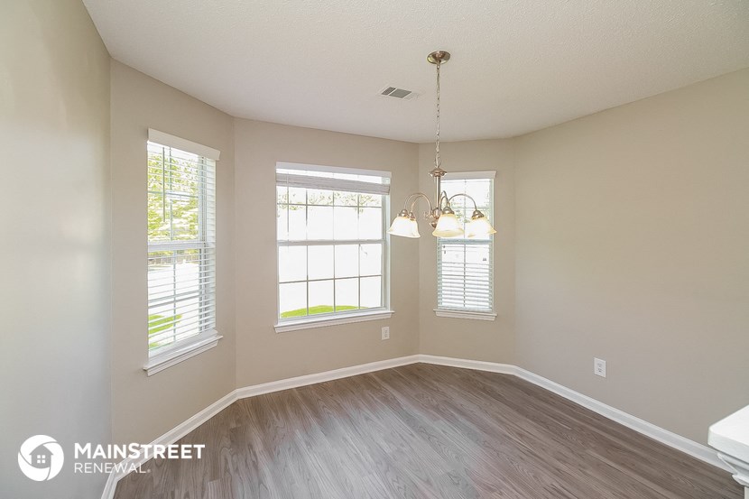 an empty living room with wood floors and windows