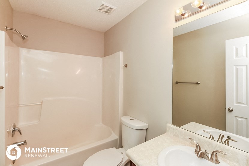 a bathroom with a tub and a sink and a toilet