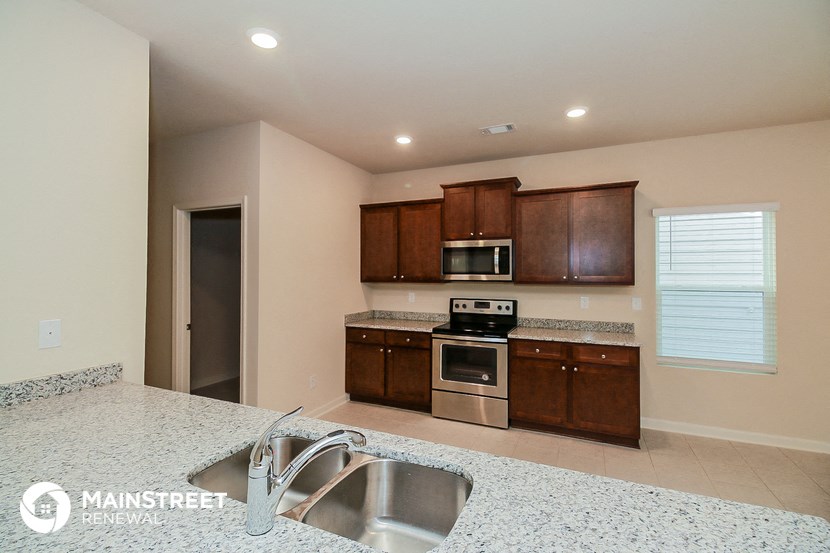 a kitchen with granite counter tops and wooden cabinets