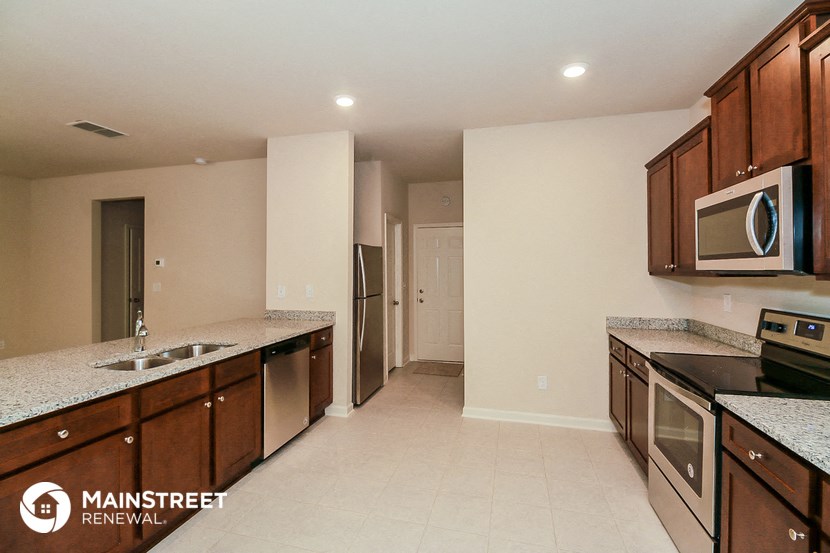 a large kitchen with stainless steel appliances and granite counter tops