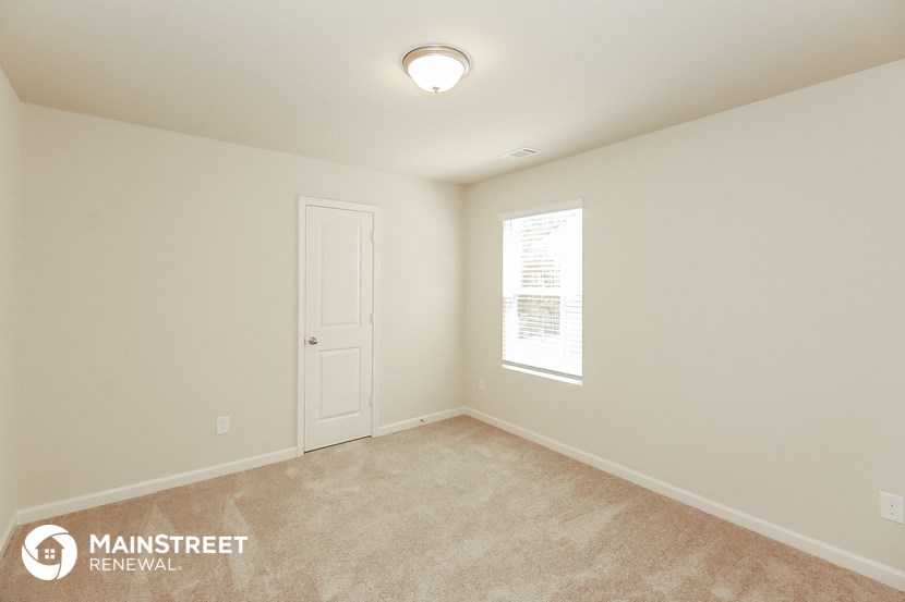 the spacious living room with carpeting and a white door