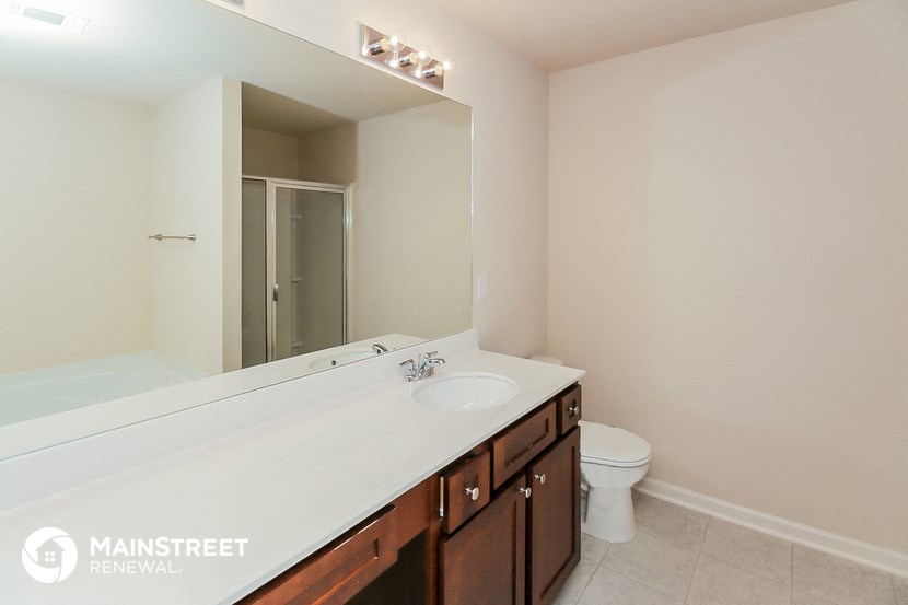 a bathroom with a large mirror and a sink and a toilet