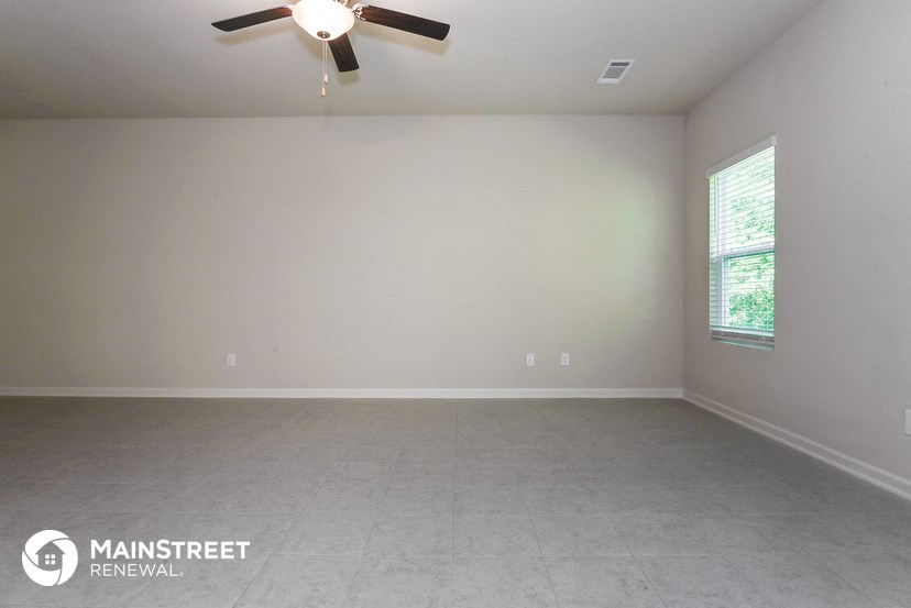 an empty room with a ceiling fan and a window