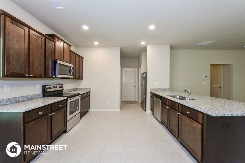 a kitchen with wooden cabinets and granite counter tops and stainless steel appliances
