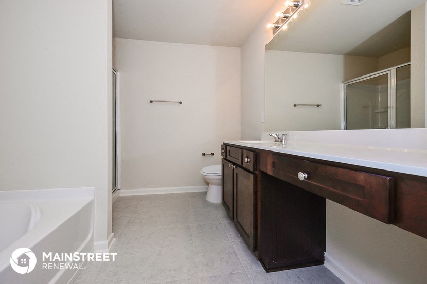 a bathroom with a large mirror and a sink and a toilet