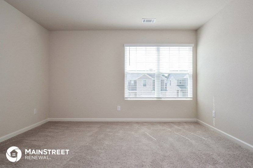 a room with a window and a carpeted floor