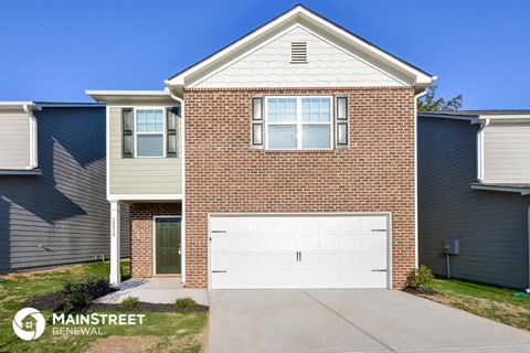 a white garage door in front of a brick house
