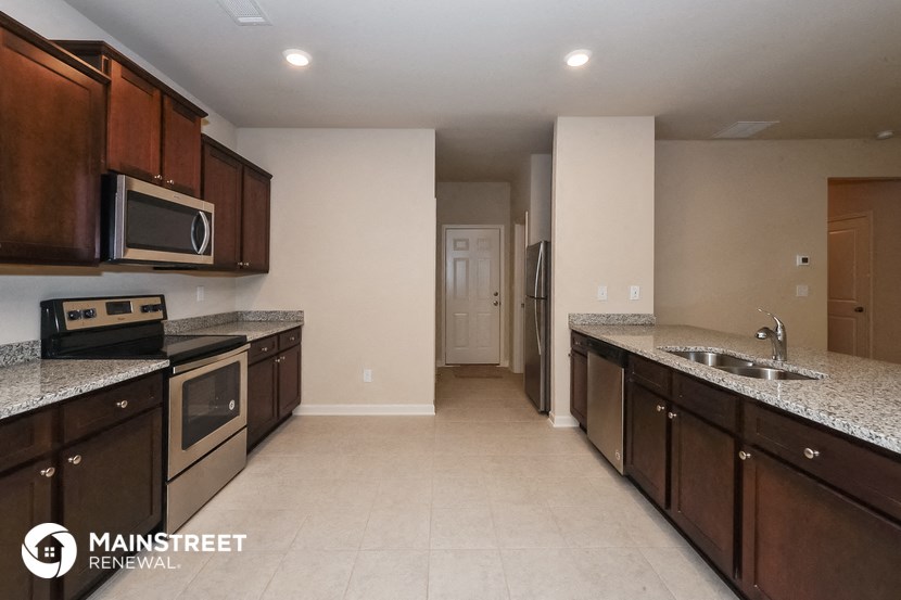 a large kitchen with granite counter tops and wooden cabinets