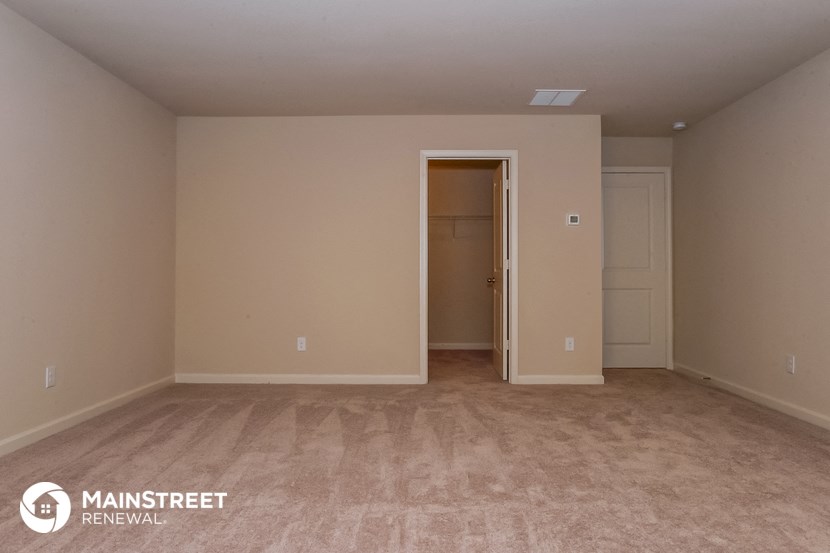a empty room with a closet and a door to a hallway