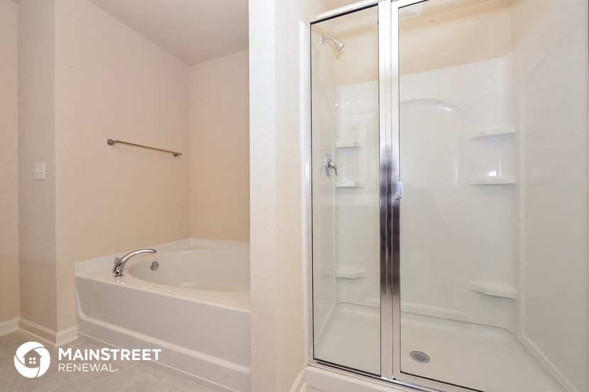 a bathroom with a shower and a tub and a sink