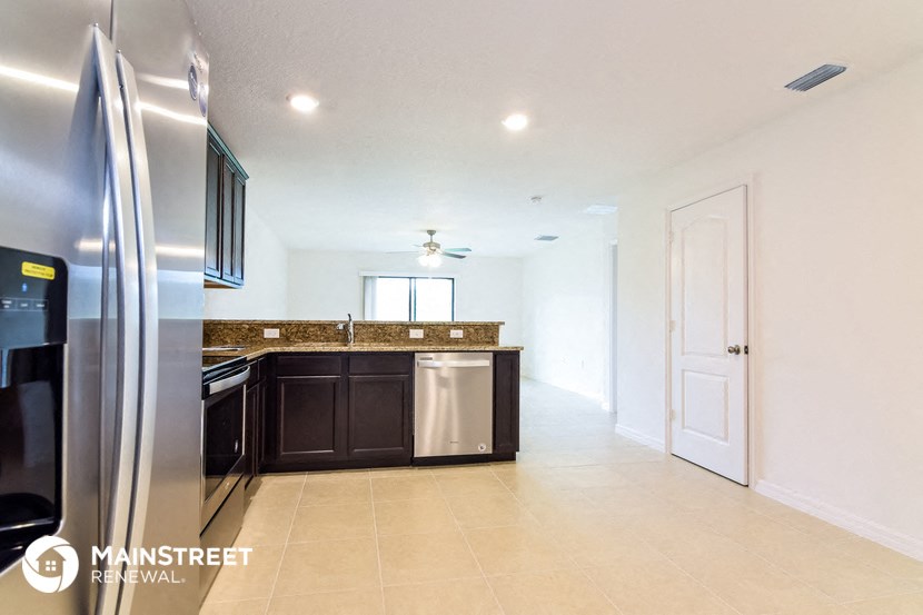 a kitchen with a stainless steel refrigerator and a sink
