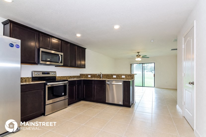 a kitchen with dark wood cabinets and stainless steel appliances