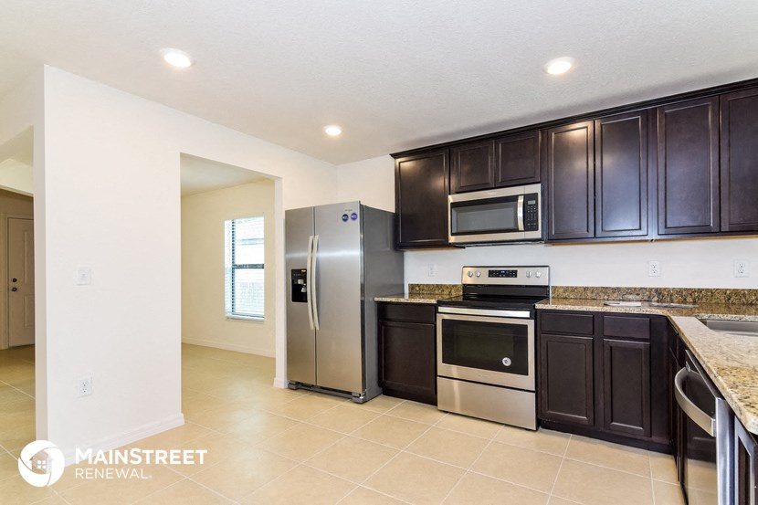 a kitchen with black cabinets and stainless steel appliances