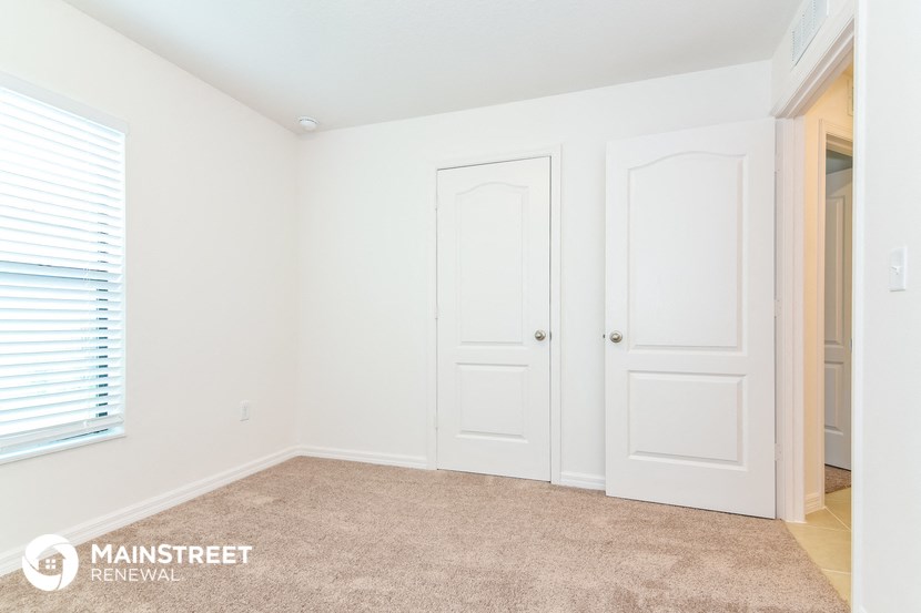 a bedroom with two white doors and a carpeted floor