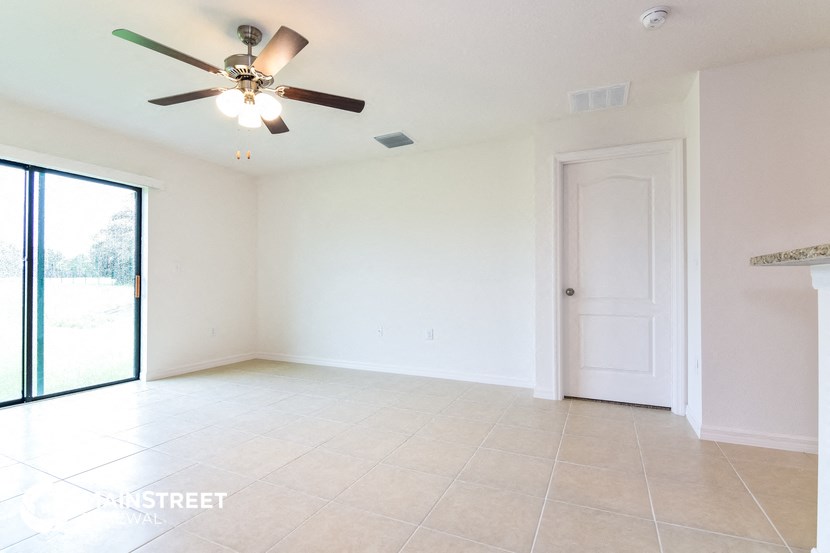 an empty living room with a ceiling fan