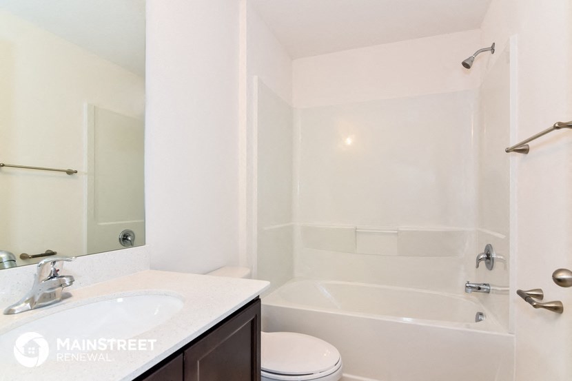 a white bathroom with a tub and a sink and a toilet