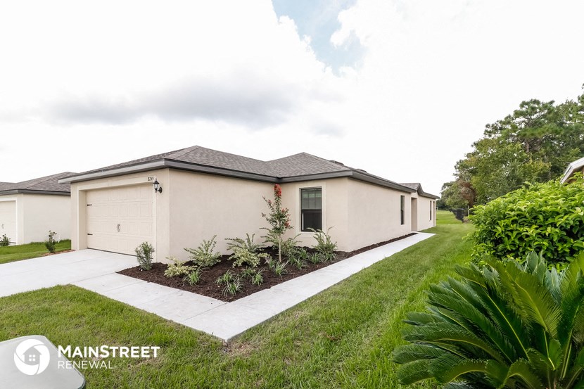 a white house with a lawn and a driveway