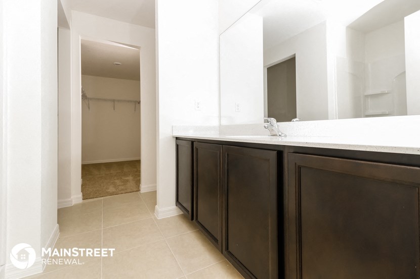a bathroom with a sink and a mirror and a closet