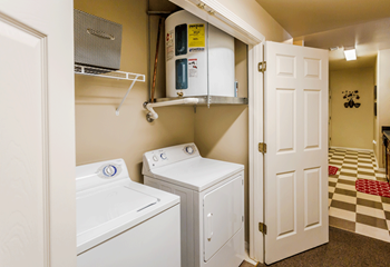 Laundry room with two doors that open on right and left. Full size washer and dryer - white.