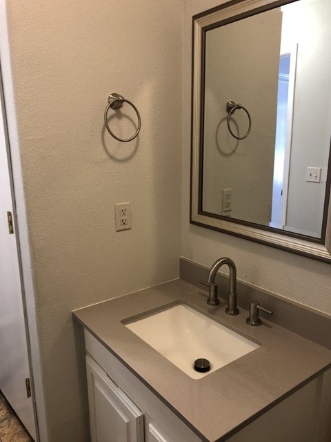 A bathroom with a sink and a mirror.